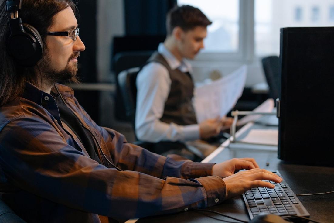 Two people working at computers in a newsroom