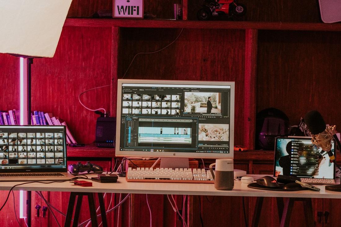 An editing desk with video editing on the monitors